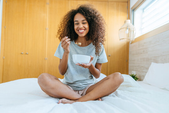 Woman sitting in bed with breakfast