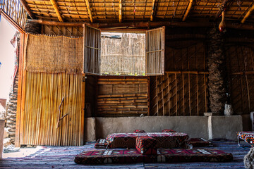 Traditional Bedouin interior with colorful carpets and cushions in a rustic desert-style room

