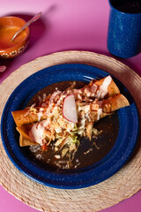 Plato de comida mexicana en contraste, flautas
