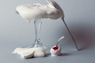 Whipped cream overflowing a glass with a cherry