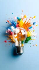 A clear lightbulb sits centrally against a pale blue backdrop, encircled by a vibrant explosion of multicolored paint splatters, symbolizing creativity and innovation