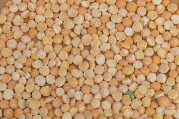 Close-up of yellow split peas, seamless texture background. A top view of colorful dry pea beans on a wooden table,