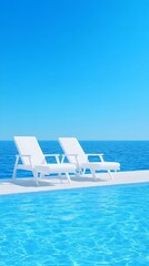 Fototapeta premium Two white lounge chairs sit poolside overlooking a calm, azure ocean under a vibrant blue sky. The scene evokes tranquility and relaxation