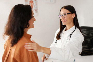 Satisfied GP doctor telling good news to middle aged female patient, congratulating on optimistic...