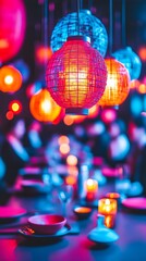 Vibrant, multicolored spherical pendant lamps illuminate a dimly lit space above a table setting with plates and candles, creating a warm, inviting, and festive atmosphere.  The blurred background