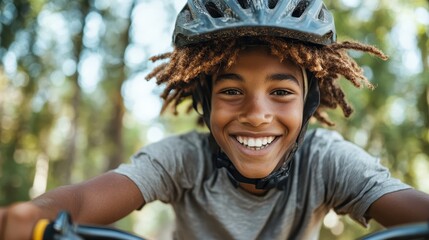 A young happy boy is riding his bicycle in a beautiful natural setting, showcasing the joy of childhood and the thrill of outdoor activities with a bright smile.