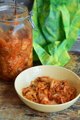 Napa cabbage kimchi in a bowl and jar, Korean fermented side dish food.
