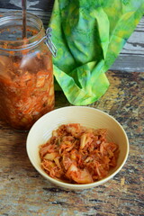 Napa cabbage kimchi in a bowl and jar, Korean fermented side dish food.
