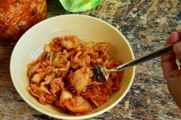 Napa cabbage kimchi in a bowl, Korean fermented side dish food.
