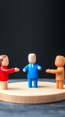 Three stylized wooden figurines, one blue, one red, one brown, stand on a small wooden disc against a dark background, suggesting interaction or negotiation.  The central blue figure appears