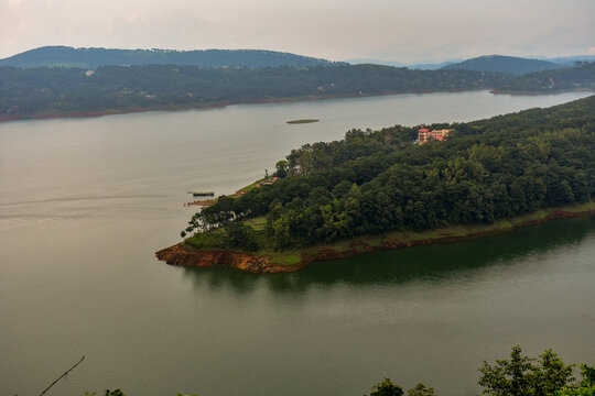 Panoramic view of Umiam lake surrounded by lush green hills and forests.