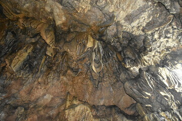 Intricate cave formations with varying textures and colors, illuminated by light.