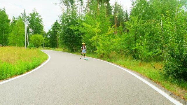 Child in protective helmet on learning skateboard in park. Girl learning to skateboard in park. lifestyle childhood concept.