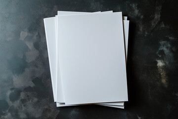 Blank sheets of paper arranged on a textured black surface