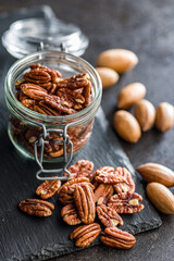Peeled pecan nuts on black table.