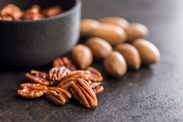 Peeled pecan nuts on black table.