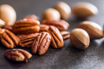 Peeled pecan nuts on black table.