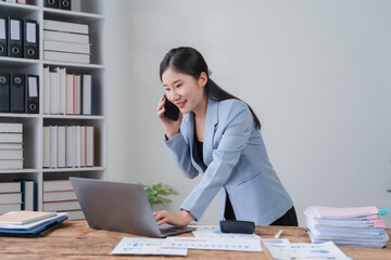 Fototapeta premium Smiling Asian Businesswoman Working at Desk