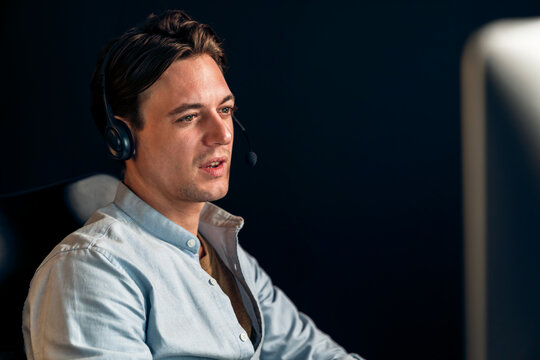 Call center consulting with customers on headphones on monitor in business paragraph with typing on pc with dynamic data marketing analysis planning at modern home office at night time. Pecuniary.