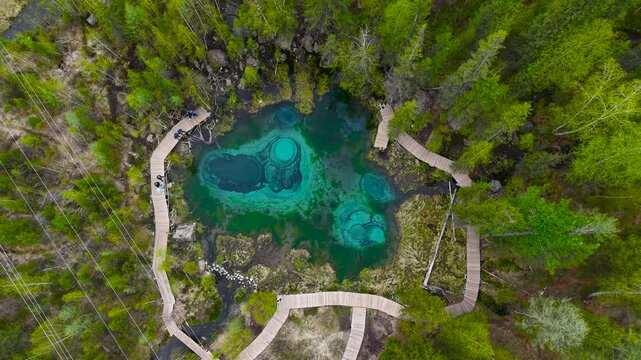 Beautiful turquoise geyser lake in the Altai Republic. Landmark - Geyser Lake, drone view