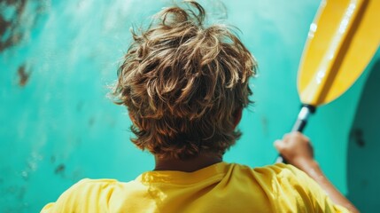 A young boy paddles a kayak through the sparkling, turquoise waters, embodying the spirit of adventure and exploring nature's beauty in a playful atmosphere.