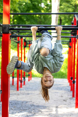 A young girl playing on bars outdoors enjoying an active lifestyle
