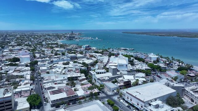 Aerial La Paz Mexico city business center to bay 3. Capital Mexican state of Baja California Sur, peninsula. Ferry, fishing, cargo and cruise ships. Beach Malecon markets. Eco tourism economy.