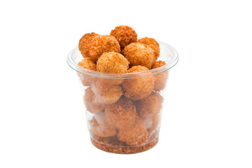 Appetizing coconut macaroon cookies in a transparent plastic disposable glass isolated on a white background. Food delivery. Fast food to go.