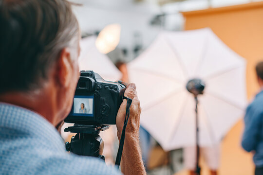 Photographer capturing a dynamic portrait session in a studio with bright background