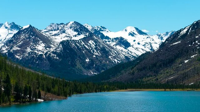 Multinsky lakes of the Altai Republic. Beautiful high-mountain lakes surrounded by mountains, cinematic 4k views from a great height. Snowy mountain peaks in the spring in the distance.