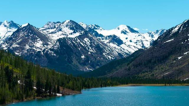 Multinsky lakes of the Altai Republic. Beautiful high-mountain lakes surrounded by mountains, cinematic 4k views from a great height. Snowy mountain peaks in the spring in the distance.
