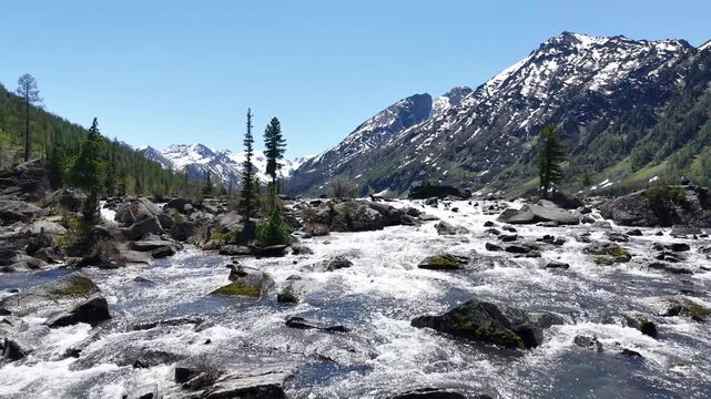 Cinematic views of a mountain lake with high mountains. Multinsky lakes are high-mountain lakes in the Altai Mountains. Rapids of water between two lakes, drone flight over running water.