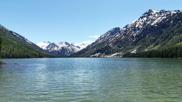 Cinematic views of a mountain lake with high mountains. Multinsky lakes are high-mountain lakes in the Altai Mountains.
Flight over the lake towards the mountains.
