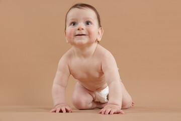 Cute little baby crawling on beige background