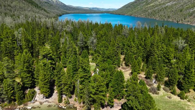 Cinematic views of a mountain lake with high mountains. Multinsky lakes are high-mountain lakes in the Altai Mountains. View from a great height of a lake surrounded by mountains 4k