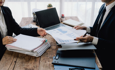 Business Professionals Exchanging Documents at Desk