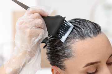Woman dyeing her hair at home, closeup