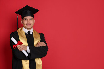 Happy student with diploma after graduation on red background. Space for text