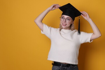 Happy student after graduation on orange background. Space for text