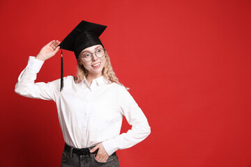 Happy student after graduation on red background. Space for text