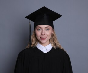 Happy student after graduation on grey background