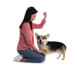 Happy woman training her dog on white background