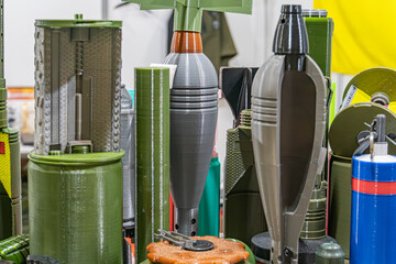 Display of green and black cylindrical objects, possibly military equipment or vehicle parts, with...