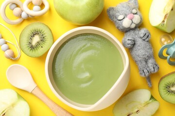 Baby food. Tasty puree in bowls, different ingredients and toys on yellow background, flat lay