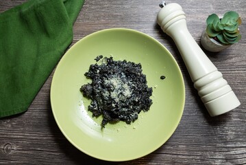 Black Squid Ink Risotto with Parmesan and Pepper Grinder.