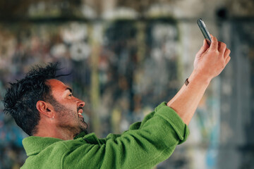 young brunette caucasian man on the street outdoors taking photo or selfie with mobile phone