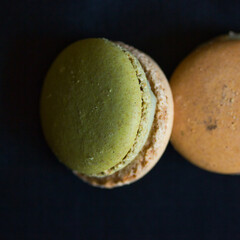 Closeup photography of two macarons on a dark background: yummy food macro.