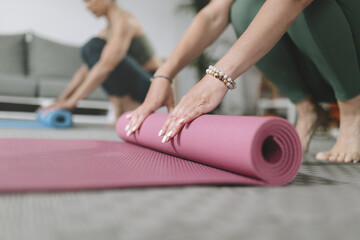 Yoga practitioners prepare their mats for a calming session in a bright indoor space during the morning hours
