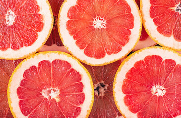 Texture of a ripe grapefruit slices as background, top view. Grapefruit background.