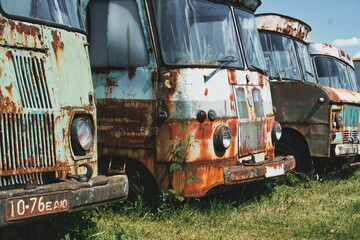 A row of abandoned and rusty Soviet-era trucks